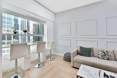 a living room with a couch and a table with chairs at Urban Gem 2BR with Stunning Views in Dubai