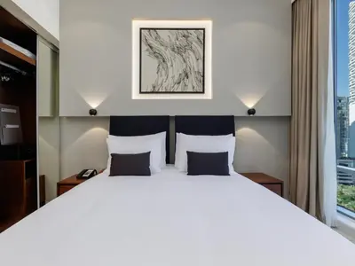 a bedroom with a large white bed with two pillows at Holiday Inn Dubai Jumeirah Village Circle by IHG in Dubai