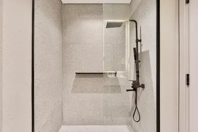 a shower with a glass door in a bathroom at Lovely Studio in Mag 900, Meydan in Dubai
