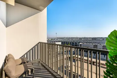 a balcony with chairs and a view of a parking lot at Lovely Studio in Mag 900, Meydan in Dubai