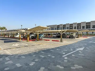 a parking lot with cars parked in front of a building at Lovely Studio in Mag 900, Meydan in Dubai