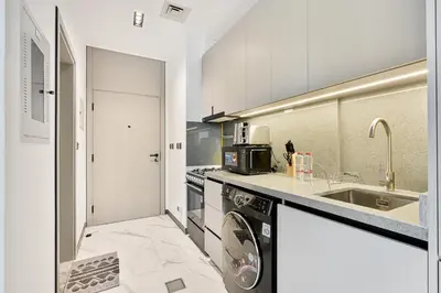 a kitchen with a washing machine and a sink at Lovely Studio in Mag 900, Meydan in Dubai