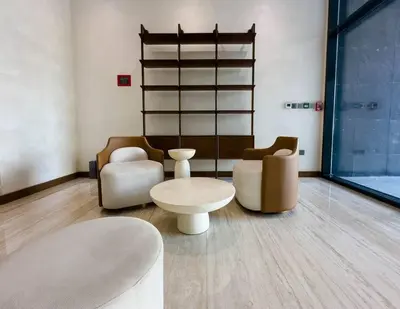 a living room with chairs and a table and a shelf at Naseem Elegant Studio Escape in Al Merkadh in Dubai