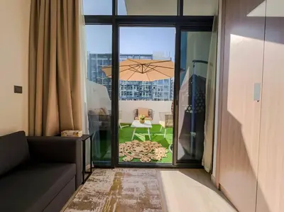 a living room with a couch and a table with an umbrella at Naseem Elegant Studio Escape in Al Merkadh in Dubai