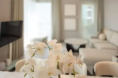 a vase filled with white flowers sitting on a table at Luxury 3BD study in Missoni with private elevator in Dubai