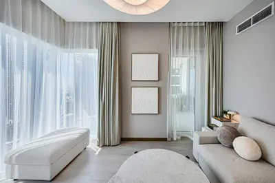 a living room with a couch and a large window at Luxury 3BD study in Missoni with private elevator in Dubai