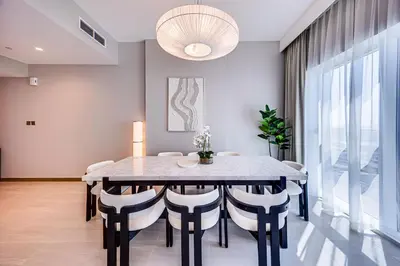 a dining room with a table and chairs at Luxury 3BD study in Missoni with private elevator in Dubai