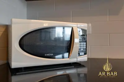 a microwave oven sitting on top of a counter at 29 Burj Boulevard - Premium 1BR - City Skyline view - Near Burj Khalifa - Downtown Dubai in Dubai