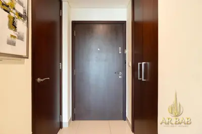 a dark wooden door in a hallway with a sign at 29 Burj Boulevard - Premium 1BR - City Skyline view - Near Burj Khalifa - Downtown Dubai in Dubai