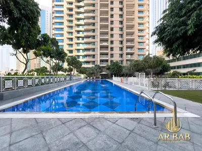 a blue swimming pool with a building in the background at 29 Burj Boulevard - Premium 1BR - City Skyline view - Near Burj Khalifa - Downtown Dubai in Dubai