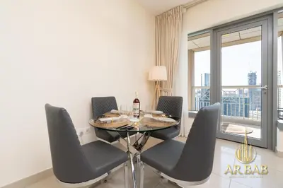 a dining room with a table and chairs and a window at 29 Burj Boulevard - Premium 1BR - City Skyline view - Near Burj Khalifa - Downtown Dubai in Dubai