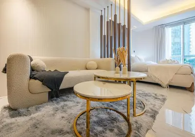 a living room with a couch and two tables at Luxurious Studio with Stunning Burj Khalifa, Pool & Lake Views Steps from Dubai Mall in Dubai