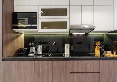 a kitchen with a sink and a microwave at Luxurious Studio with Stunning Burj Khalifa, Pool & Lake Views Steps from Dubai Mall in Dubai