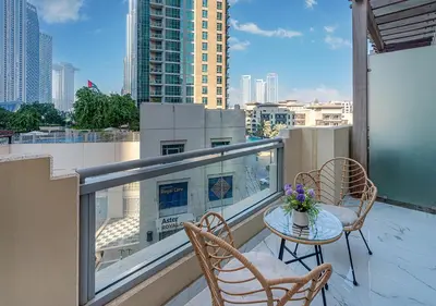 a balcony with a table and chairs on a balcony at Luxurious Studio with Stunning Burj Khalifa, Pool & Lake Views Steps from Dubai Mall in Dubai
