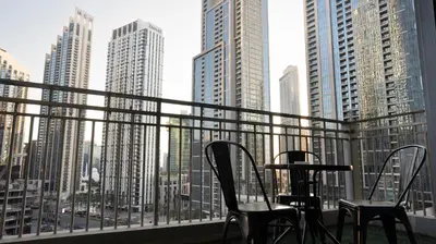 a balcony with chairs and a table and a view of a city at Boho Chic Haven Burj Khalifa view in Dubai
