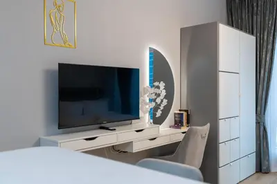 a living room with a tv and a white cabinet at White Sage Stunning New Studio in Marina in Dubai