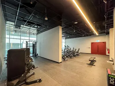 a gym with several rows of exercise equipment in a room at Stylish Studio APT with Pool and Gym in Dubai
