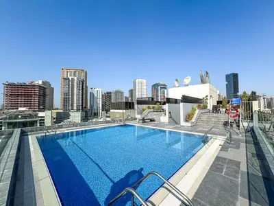 a large swimming pool on the roof of a building at Stylish Studio APT with Pool and Gym in Dubai