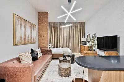 a living room with a couch and a table at Stylish Studio APT with Pool and Gym in Dubai