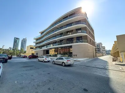a parking lot with cars parked in front of a building at Stylish Studio APT with Pool and Gym in Dubai