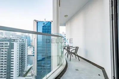 a balcony with a table and chairs on top of a building at Upscale 3BR Apartment in Bayz Tower, Business Bay by Deluxe Holiday Homes in Dubai