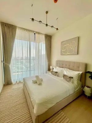a bedroom with a large bed with a large window at Stylish 1br Apt In Jvc Pool Access & Parking in Dubai
