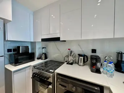 a kitchen with white cabinets and a stove top oven at Stylish 1br Apt In Jvc Pool Access & Parking in Dubai