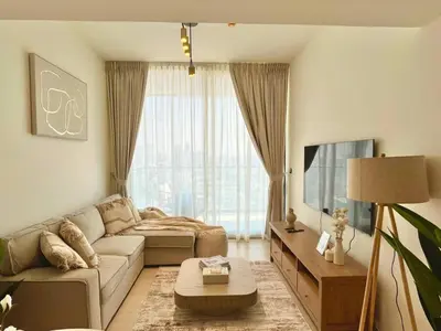 a living room with a couch and a large window at Stylish 1br Apt In Jvc Pool Access & Parking in Dubai