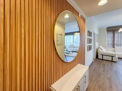 a bathroom with a mirror on a wooden wall at DreamShoma- Deluxe 1BR With Lake View in Dubai