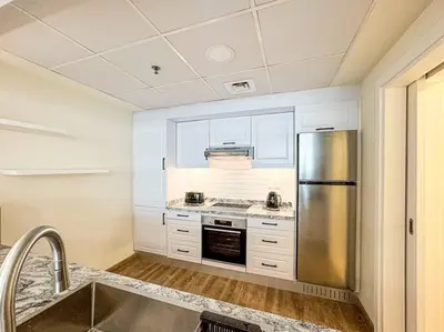 a kitchen with a stainless steel refrigerator and a sink at DreamShoma- Deluxe 1BR With Lake View in Dubai