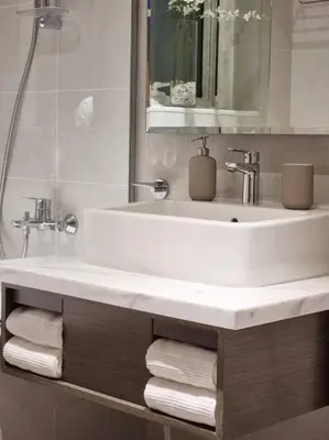 a bathroom with a sink and a mirror and towels at 2 Bedroom DAMAC Prive Apartment in Dubai
