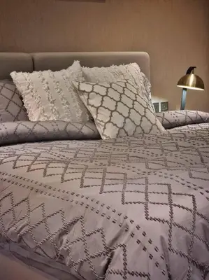 a bed with a white comforter and pillows on it at 2 Bedroom DAMAC Prive Apartment in Dubai