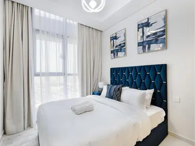 a bedroom with a large bed with a blue headboard at ALiving Elegant 2BR plus Maid's Room I Aykon City, Business Bay- 4016 in Dubai