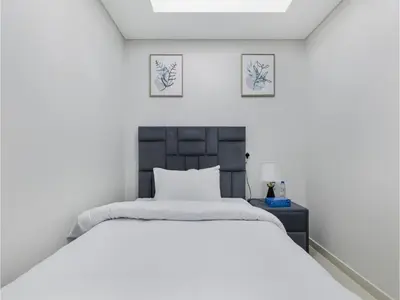 a bedroom with a bed and two pictures on the wall at ALiving Elegant 2BR plus Maid's Room I Aykon City, Business Bay- 4016 in Dubai