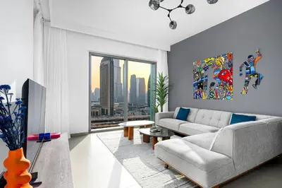 a living room with a couch and a large window at Arthouse Views - Burj Khalifa view & Dubai Mall access in Dubai