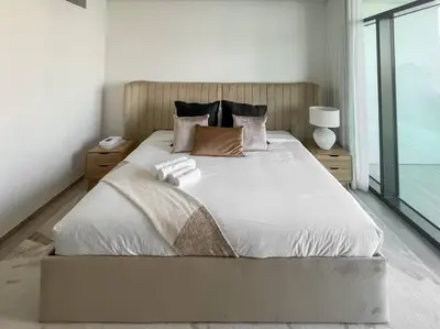 a bedroom with a large bed with white sheets and pillows at Waves - Luxurious 11th Floor Retreat in Palace Residences in Dubai