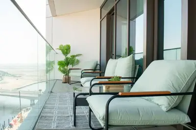 a hotel room with chairs and a balcony with a view at Waves - Luxurious 11th Floor Retreat in Palace Residences in Dubai
