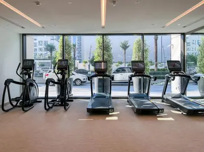 a gym with cardio machines in a room with a large window at Waves - Luxurious 11th Floor Retreat in Palace Residences in Dubai