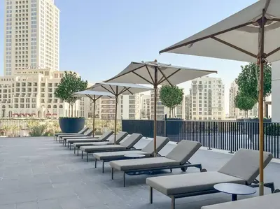 a row of lounge chairs and umbrellas on a patio at Waves - Luxurious 11th Floor Retreat in Palace Residences in Dubai