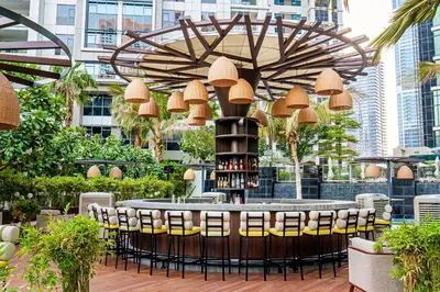 a bar with chairs and a table with wine bottles at Taj Dubai in Dubai