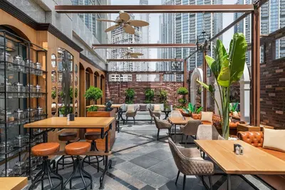a restaurant with tables and chairs and tall buildings at Taj Dubai in Dubai