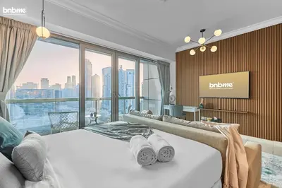 a bedroom with a large bed and a large window at bnbme - Chic Downtown Studio Near Burj Khalifa Dubai Mall w Pool Gym Concierge in Dubai