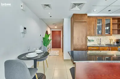 a kitchen with a table and chairs in a room at bnbme - Chic Downtown Studio Near Burj Khalifa Dubai Mall w Pool Gym Concierge in Dubai
