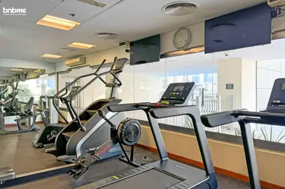 a gym with treadmills and ellipticals in a building at bnbme - Chic Downtown Studio Near Burj Khalifa Dubai Mall w Pool Gym Concierge in Dubai