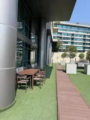a wooden table and chairs next to a building at Marina Quays West - Modern One Bedroom in Marina in Dubai