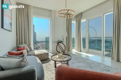 a living room with a chandelier and large windows at HiGuests - Beachside Oasis Stylish 2BR Apartment in La Vie in Dubai
