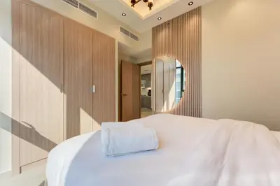 a bedroom with a white bed and a mirror at Chic 1 Bed Oasis in Azizi Riviera in Dubai
