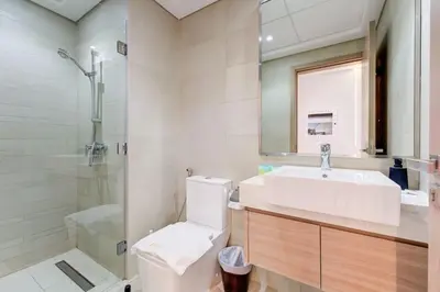 a bathroom with a toilet and a sink and a shower at Chic 1 Bed Oasis in Azizi Riviera in Dubai