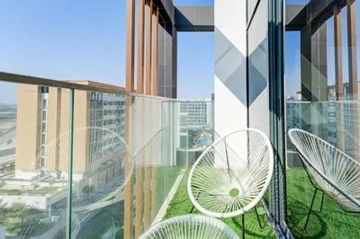 a balcony with chairs and tables on a building at Chic 1 Bed Oasis in Azizi Riviera in Dubai
