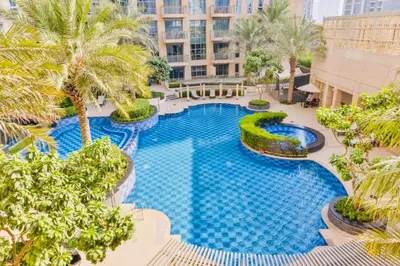 an overhead view of a swimming pool with palm trees at The Skyline Suite Luxury Downtown Retreat in Dubai